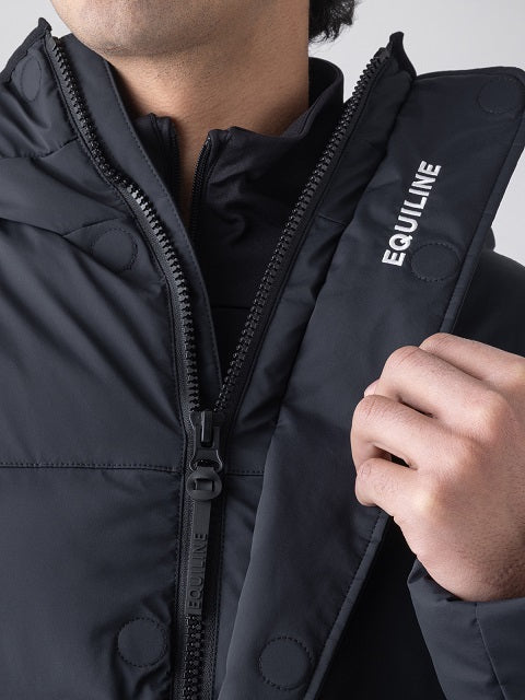 Close-up of a person wearing a black puffer jacket with a high collar, front zipper, snap buttons, and the brand name 'EQUILINE' printed in white on the shoulder.