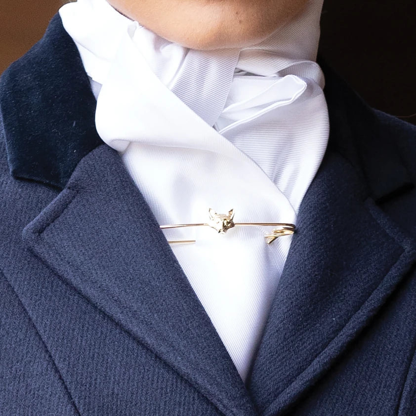 Gold fox stock pin on a white stock with a navy jacket