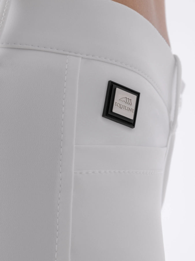 Close-up of white riding pants with a brand logo on a white background