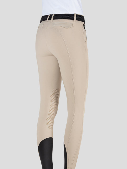 woman wearing beige equiline breeches with logo on a white background