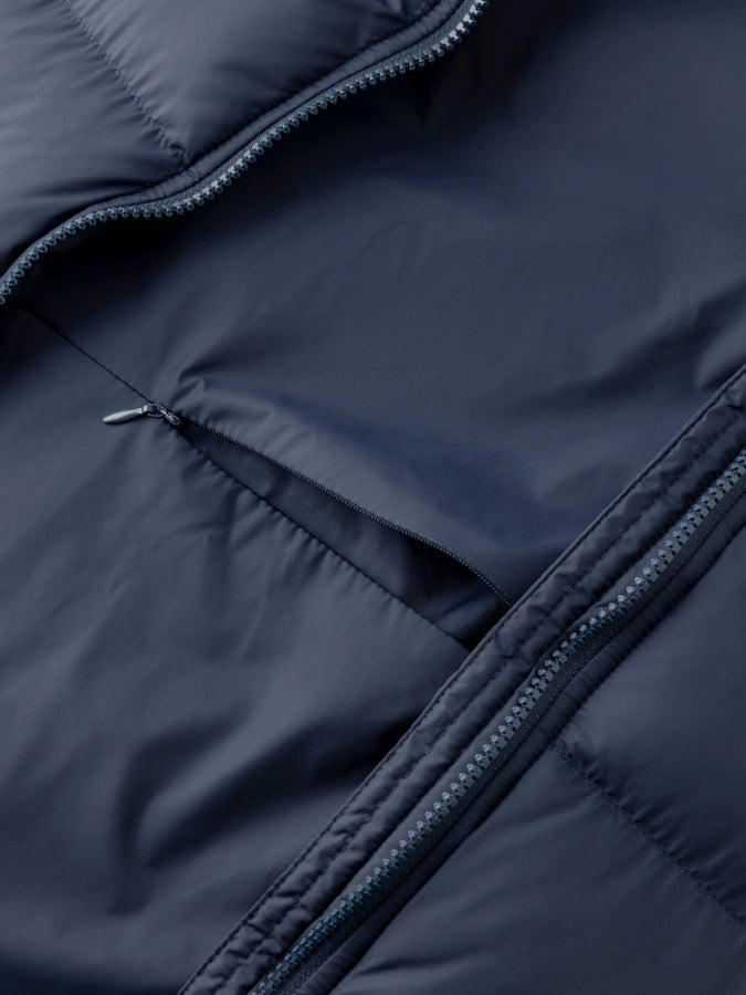Close-up of a navy blue puffer jacket with zipper details