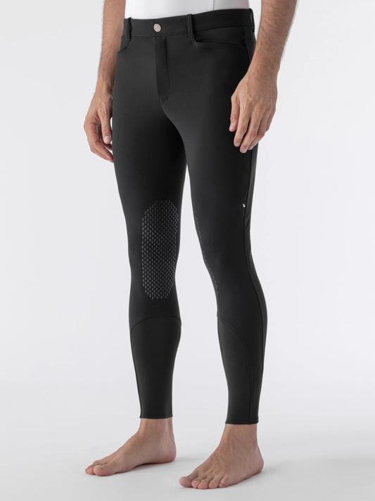 Person wearing black riding pants on a white background