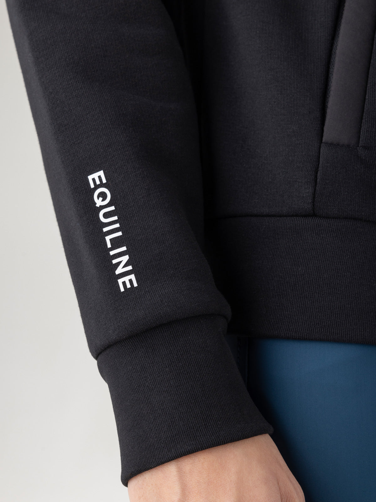 Black sweatshirt with 'EQUILINE' logo on sleeve against a neutral background
