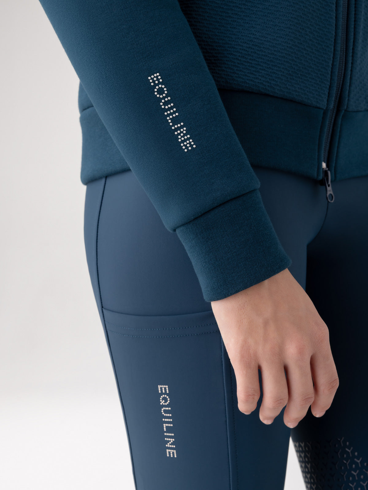Navy blue athletic outfit with 'EQUILINE' branding on sleeves and waistband against a light gray background