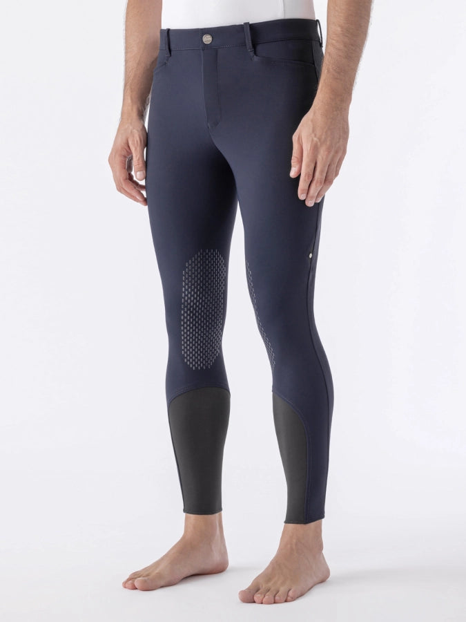 Person wearing navy riding pants on a white background
