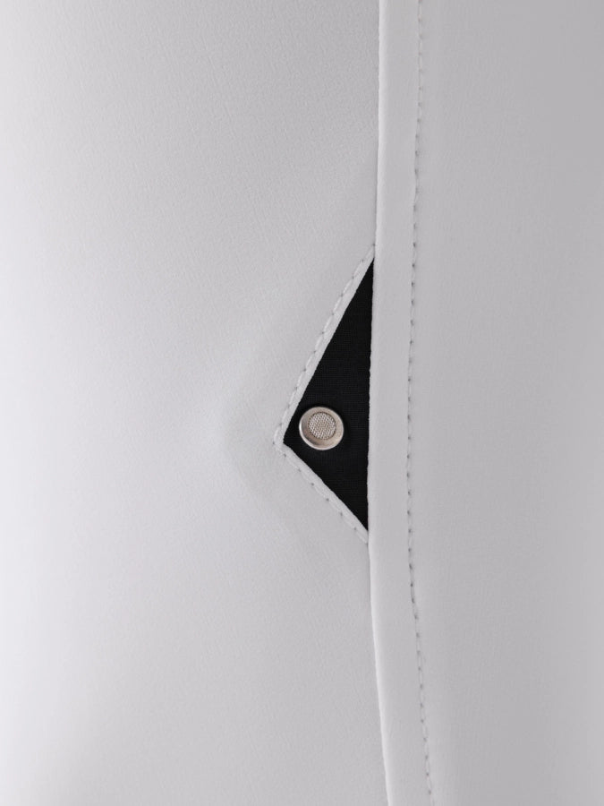 Close-up of a white fabric with a black corner and a metal button on a white background