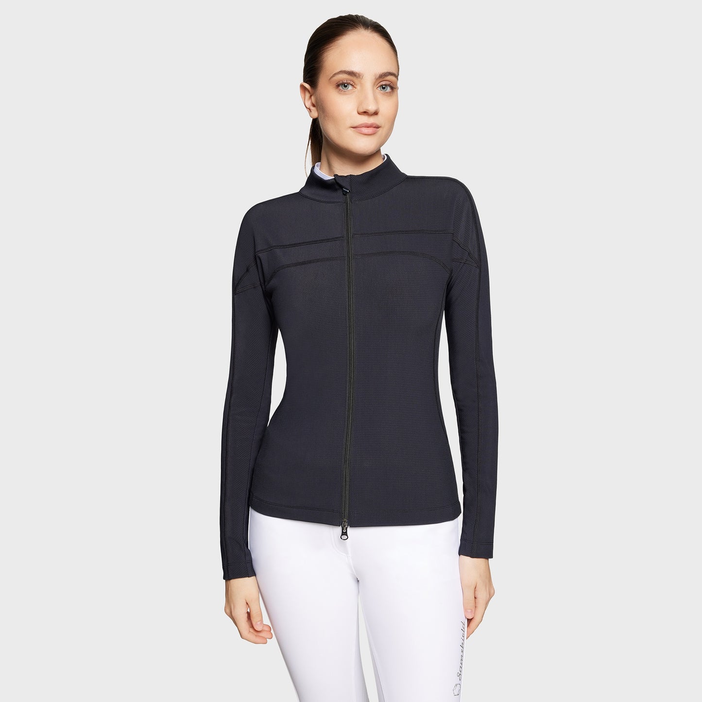 Woman wearing a black long-sleeve top with a zipper on a white background