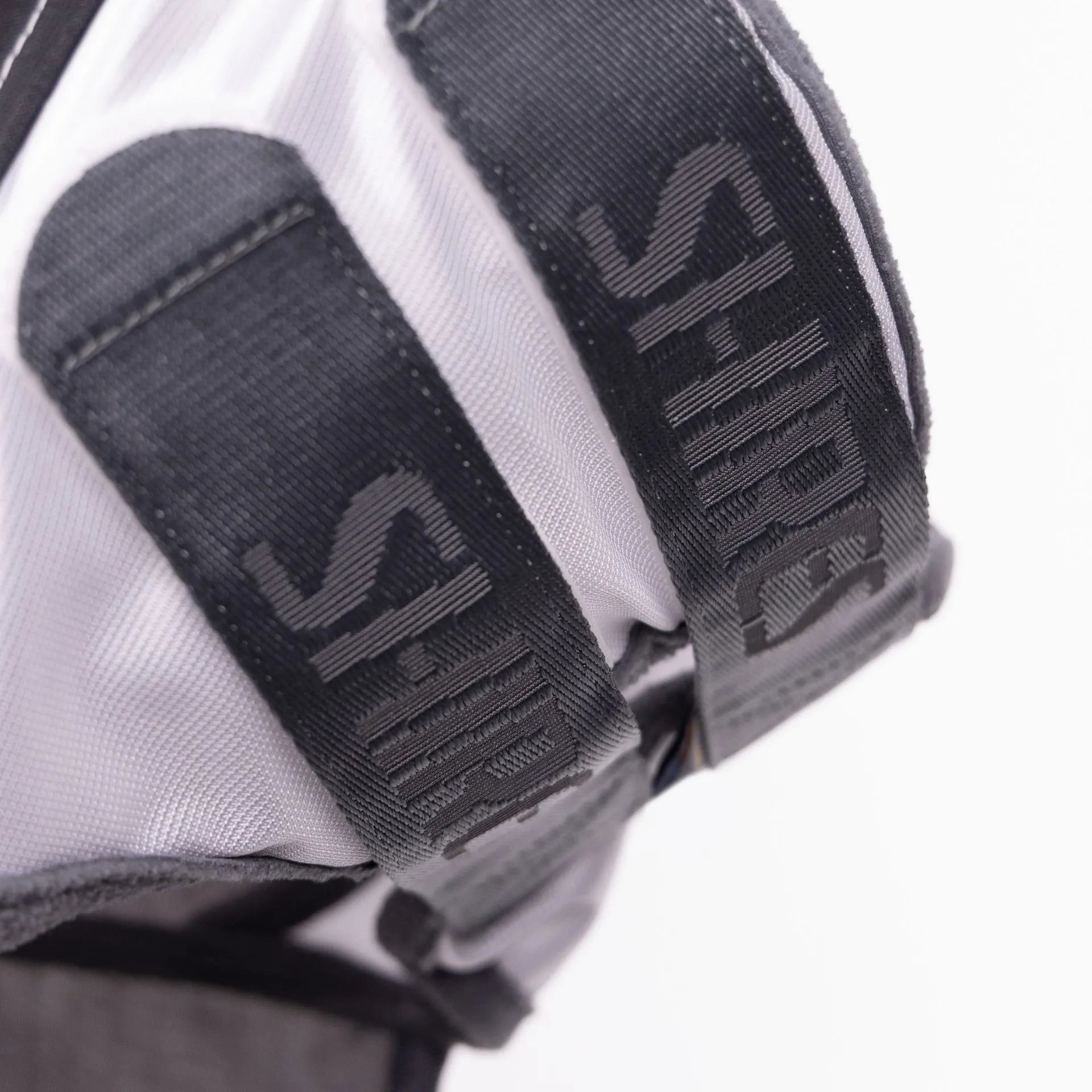 Close-up of a white and black glove with 'S' logo on a white background