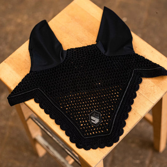 Black fly veil with crystal logo on a wooden stool