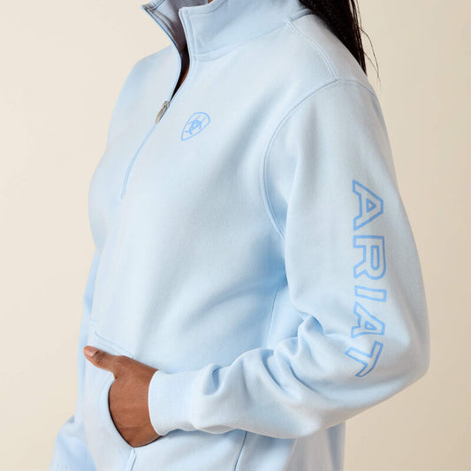 Light blue fleece jacket with 'Ariat' branding on a beige background
