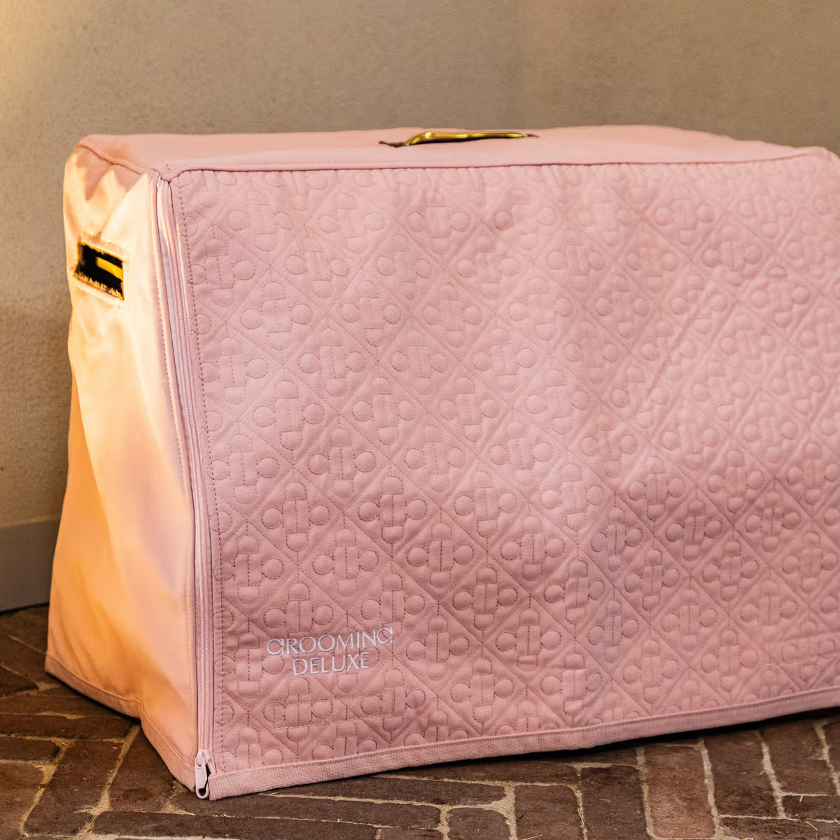 Pink grooming box with quilted texture on a brick floor.