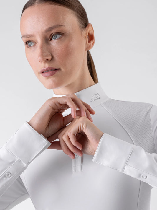 Woman wearing a white dress shirt with a close-up of the collar and cuffs.