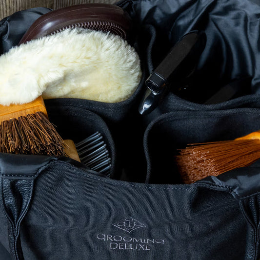 Grooming bag full of grooming brushes and Grooming Deluxe branding.