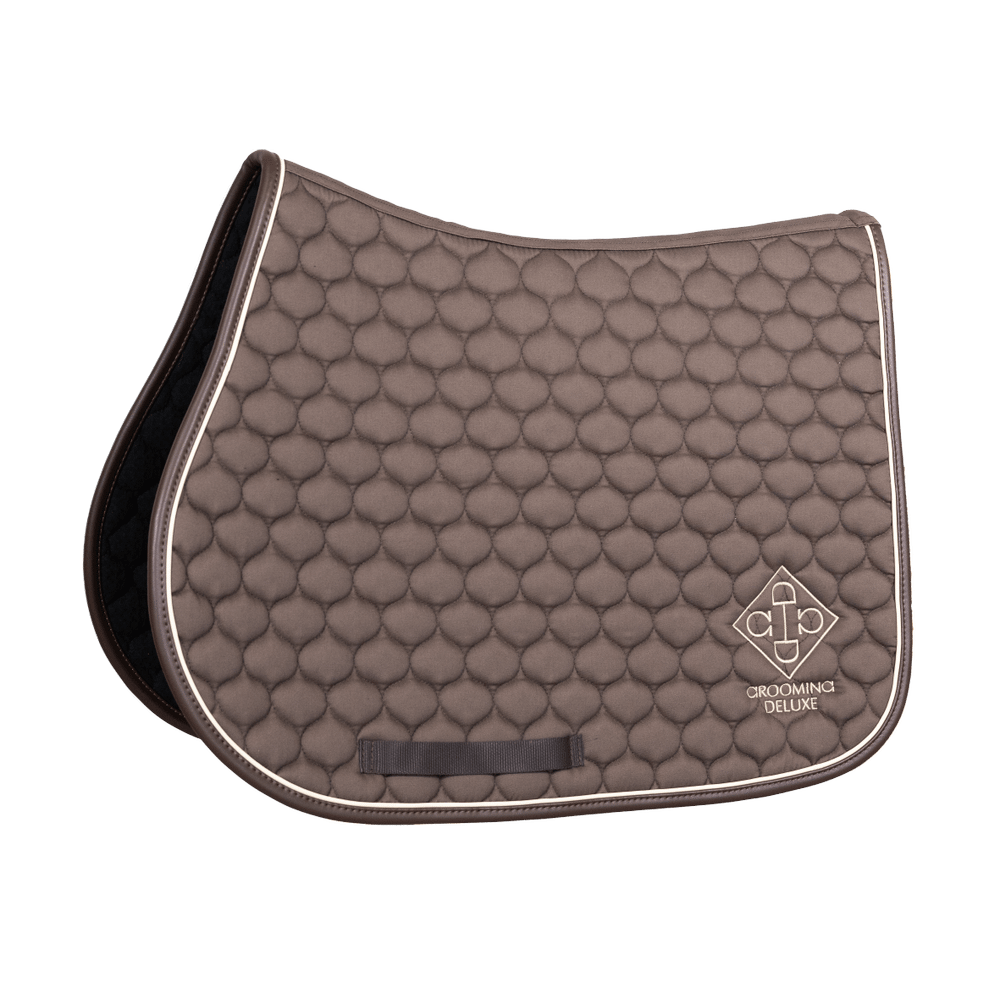 Brown quilted saddle pad with white border on a black background
