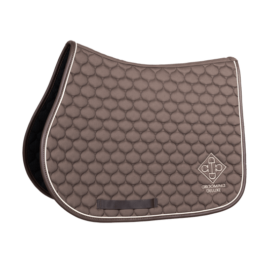 Brown quilted saddle pad with white border on a black background