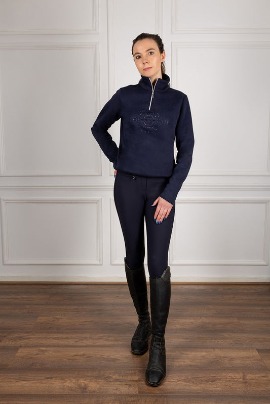 Woman wearing a navy equestrian outfit in a studio setting