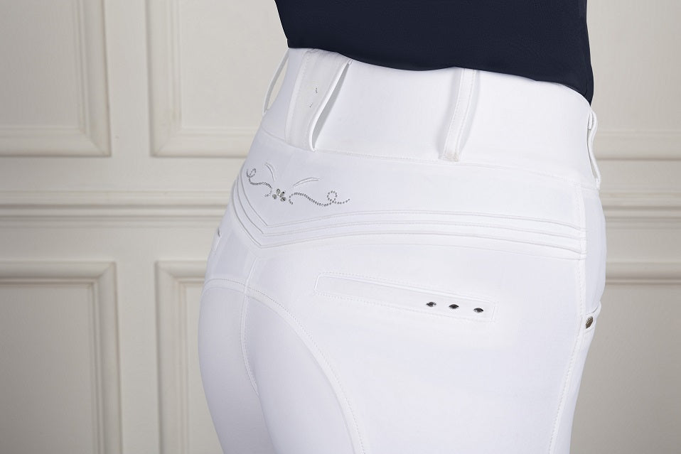 White riding pants with embroidery on a neutral background