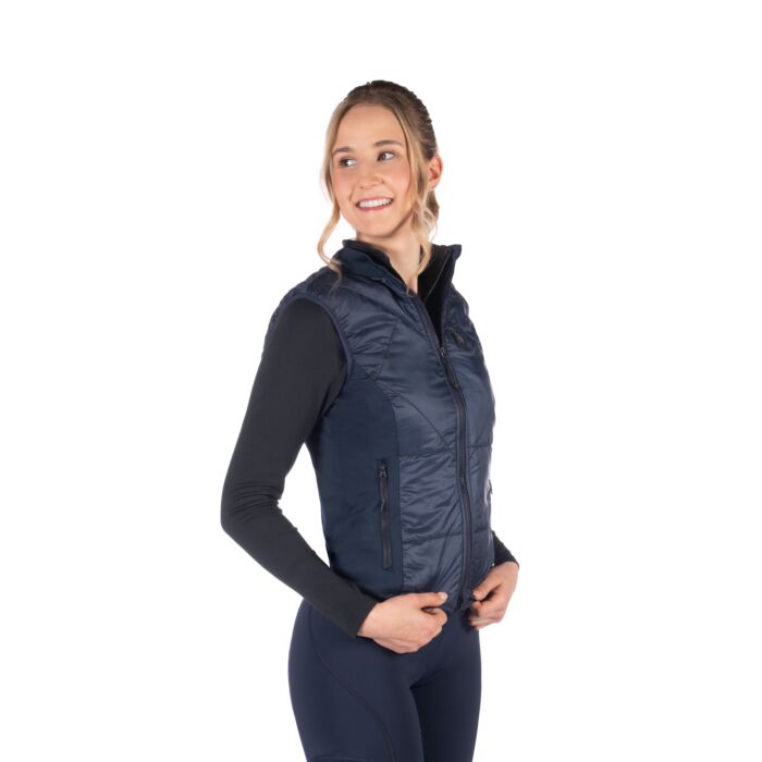 Woman wearing a navy blue puffer vest on a white background