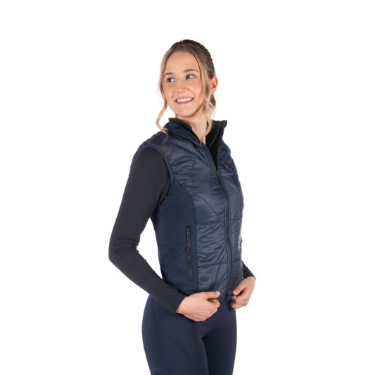 Woman wearing a navy blue puffer vest on a white background