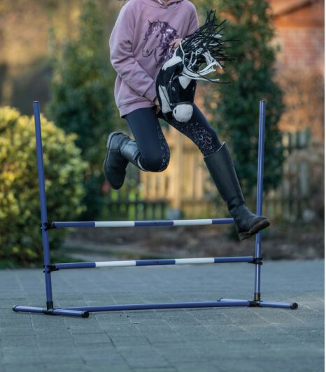 Girl jumping a hobby horse jump 