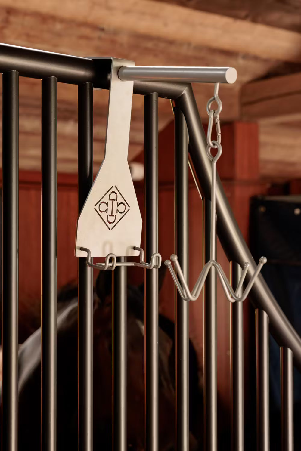 Metal hook attached to a metal railing with a blurred background