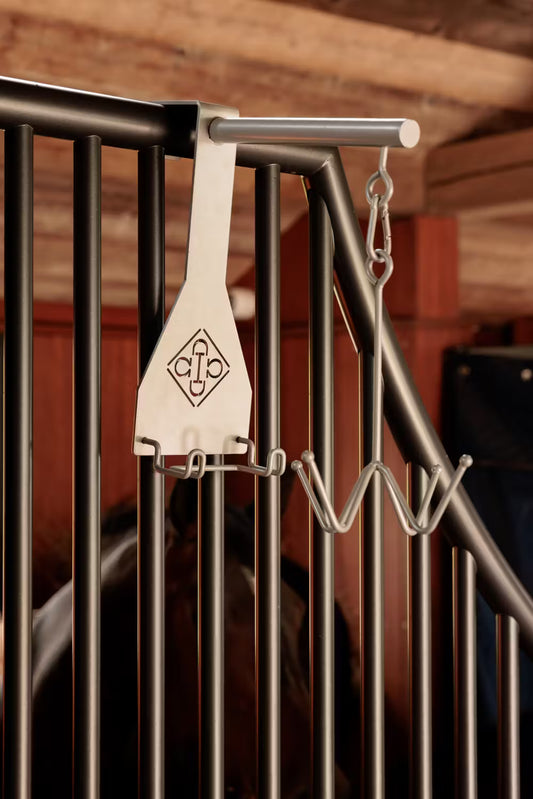 Metal hook attached to a metal railing with a blurred background