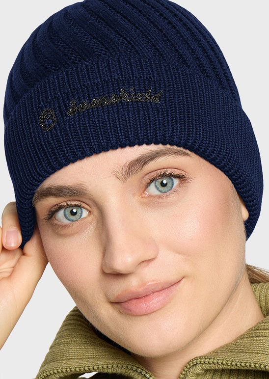 A close-up of a woman wearing a navy blue ribbed knit beanie with 'Samshield' embroidered in black on the front, against a light gray background.