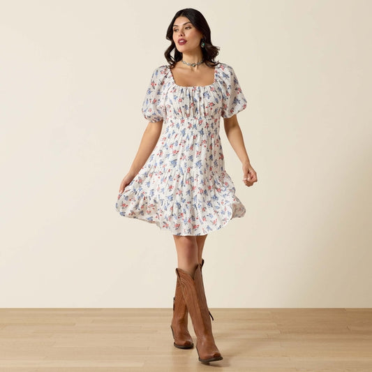 Woman wearing a floral dress with brown boots against a beige background