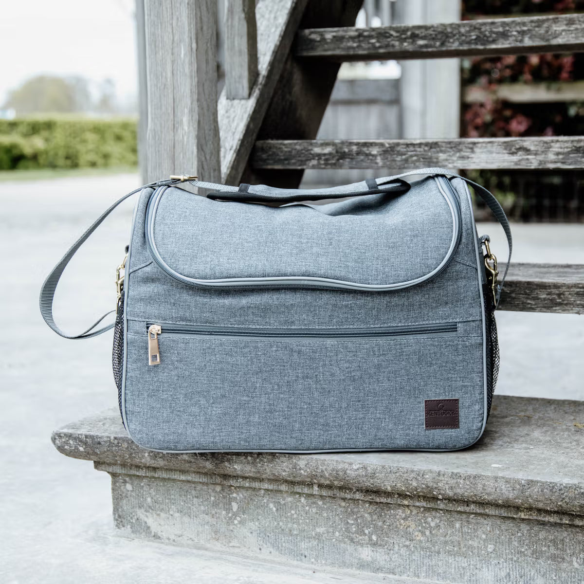 Gray grooming bag on a stone ledge with a wooden bench in the background
