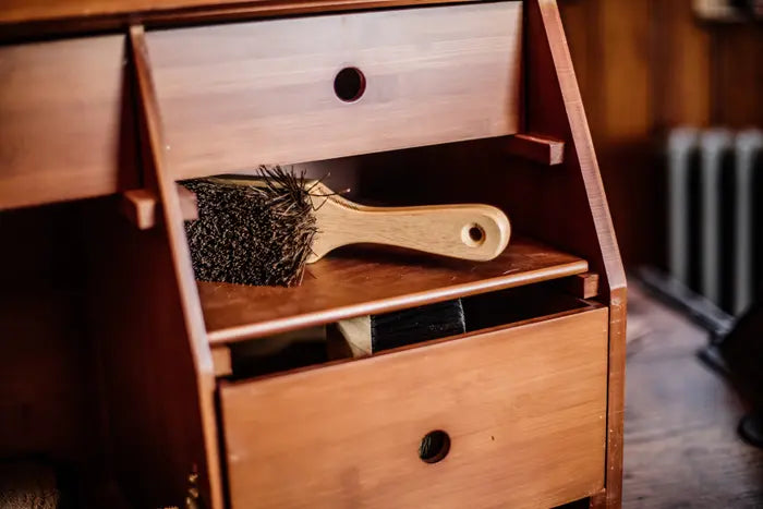 deluxe grooming box with wooden brush with brown bristles inside of it