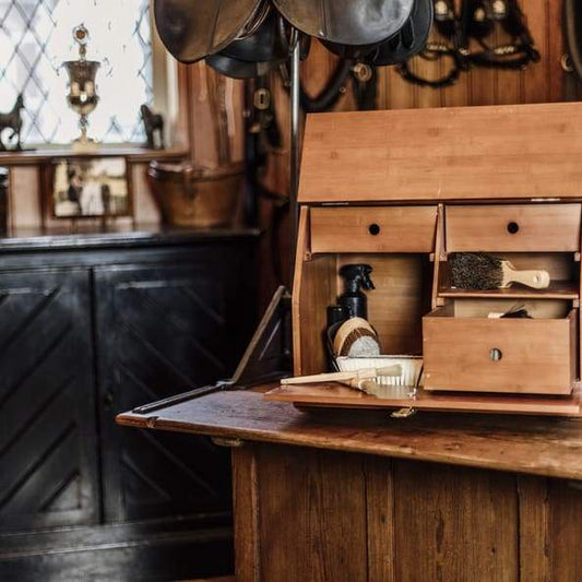 A deluxe show grooming box made of bamboo, featuring multiple compartments and gold snap closure, placed on a wooden table.