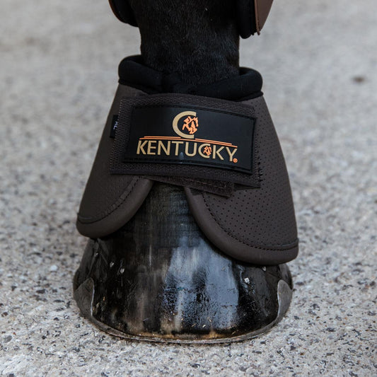 Horse hoof with a protective boot branded 'Kentucky' on a concrete surface.