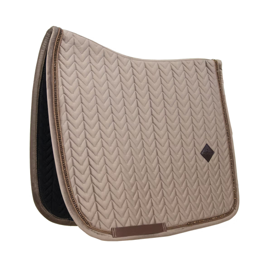 Beige quilted saddle pad with brown border on a white background