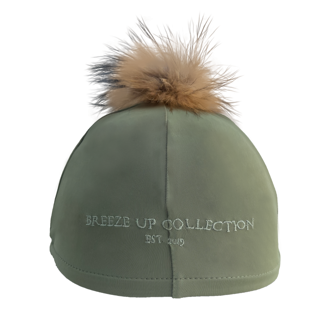 Green cap with fur pom-pom on a white background