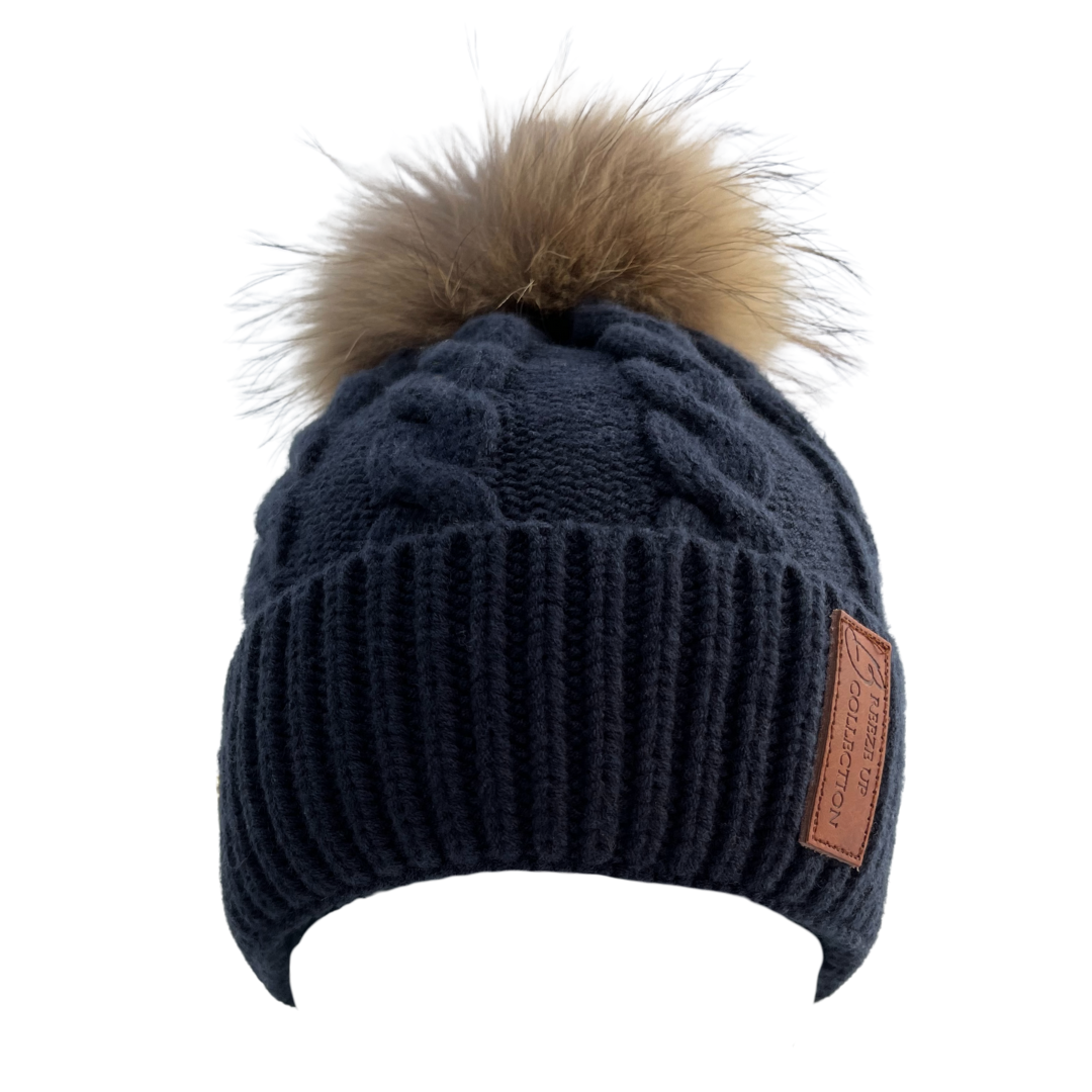 Navy blue knit beanie with a brown faux fur pom-pom on a white background