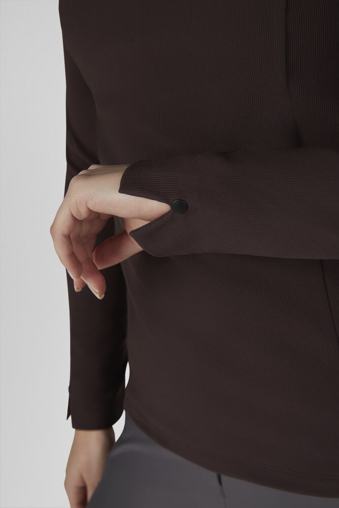 Close-up of a person wearing a dark brown ribbed long-sleeve top, showing the sleeve cuff with a single black button and the hand adjusting or touching it.