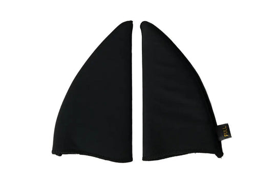 A pair of black neoprene shark fin wing covers, shown flat against a solid white background. A small black fabric tag with yellow text is attached to the lower right edge of the right fin.