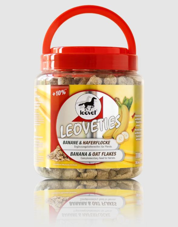 A jar of Leoveties Banana & Oat Flakes horse treats with a red handle lid, set against a light gray background with a reflection below.