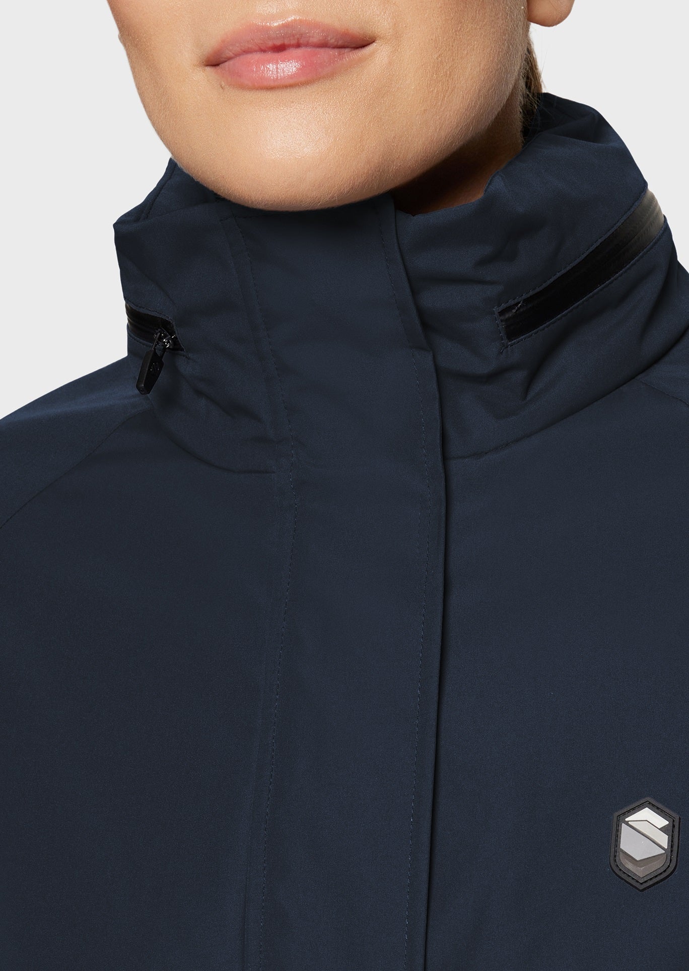 Woman wearing a navy jacket on a beige background