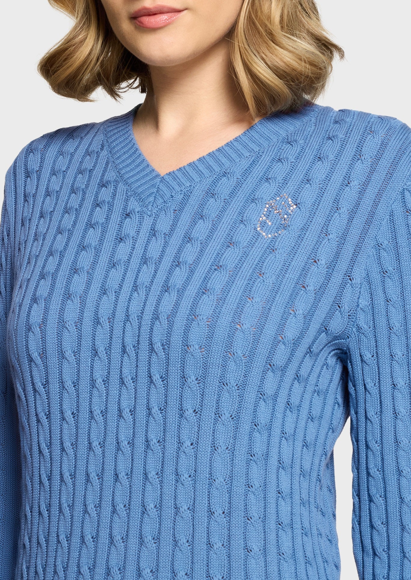 Woman wearing a blue jumper on a beige background
