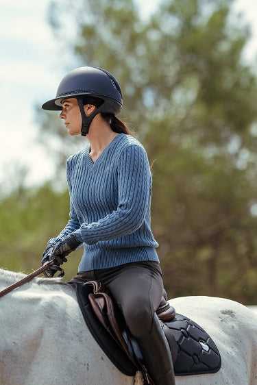 Woman riding a horse in an outdoor setting