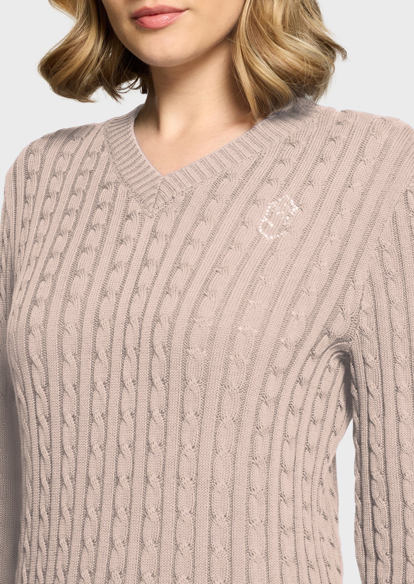 Woman wearing a pink jumper on a beige background