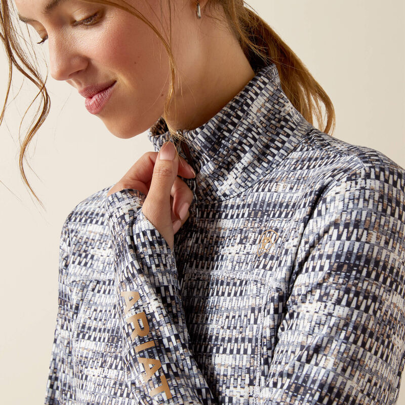 Woman wearing a patterned jacket with a visible brand logo on a beige background