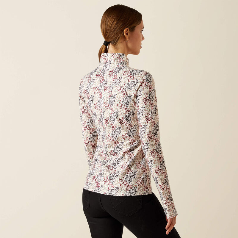 Woman wearing a floral patterned long-sleeve top against a beige background