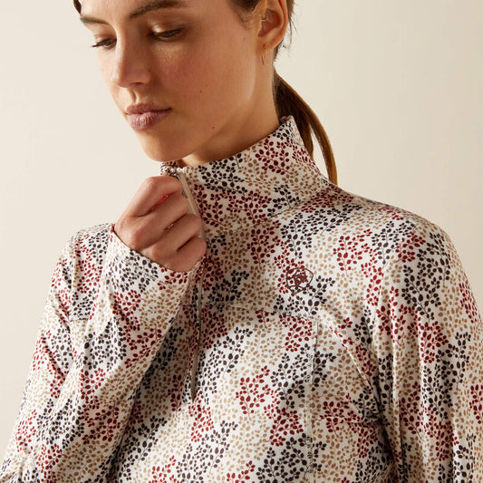 Woman wearing a patterned blouse against a plain background