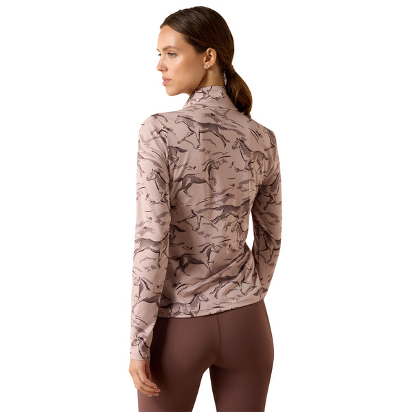 A woman shown from the back wearing a long-sleeve athletic top with a dusty pink and brown horse pattern, paired with brown leggings, against a solid white background.