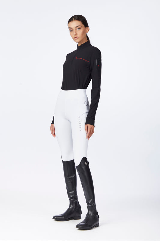 Person wearing a black top, white pants, and black riding boots on a white background