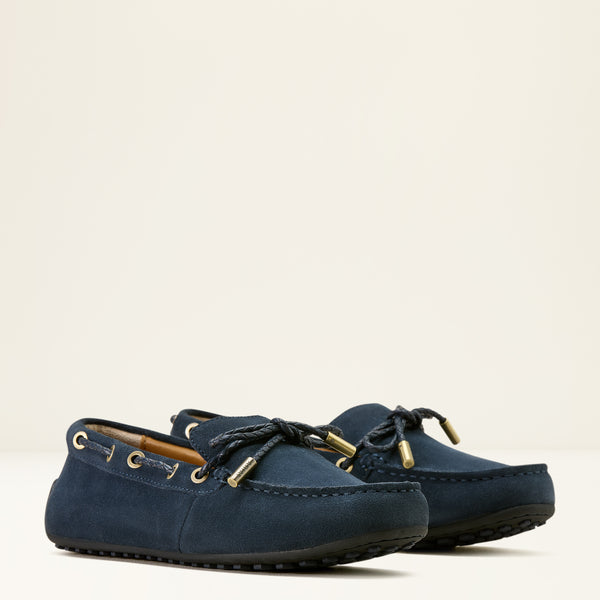 Pair of navy blue loafers with gold accents on a light beige background