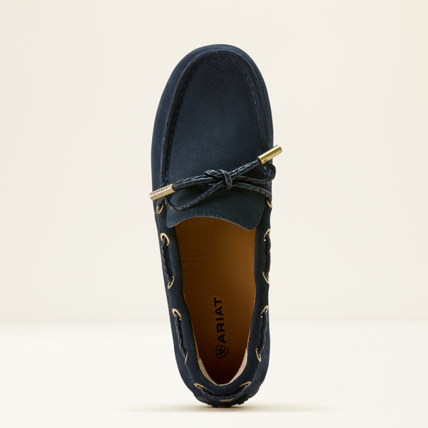 Navy blue loafer shoe with gold accents on a beige background