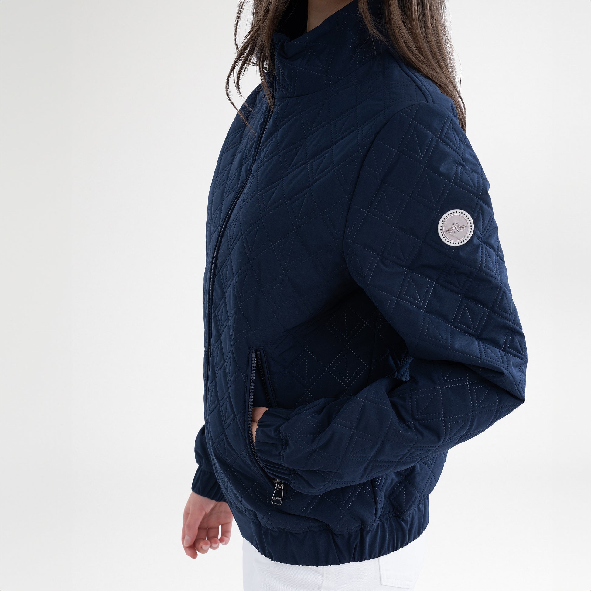 Girl wearing a navy jacket and white breeches on a white background